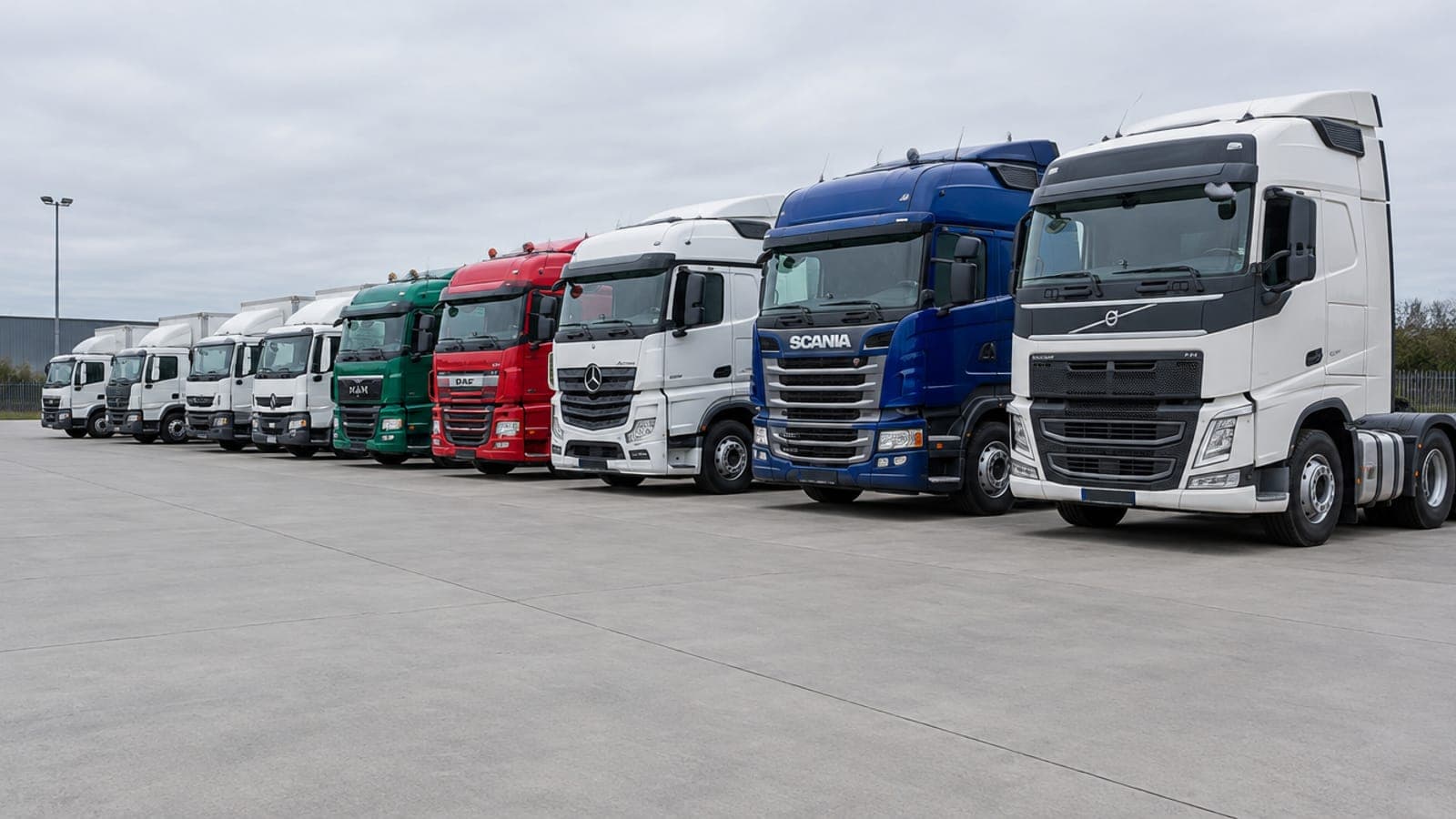 A line of prime movers parked in a transport depot yard
